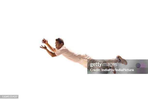 fielder diving to take a ctach - cricket player white background stock-fotos und bilder