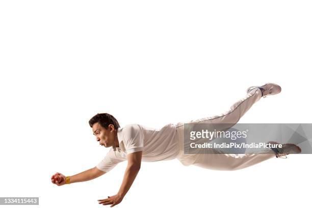 fielder diving to take a ctach - cricket player white background stock-fotos und bilder