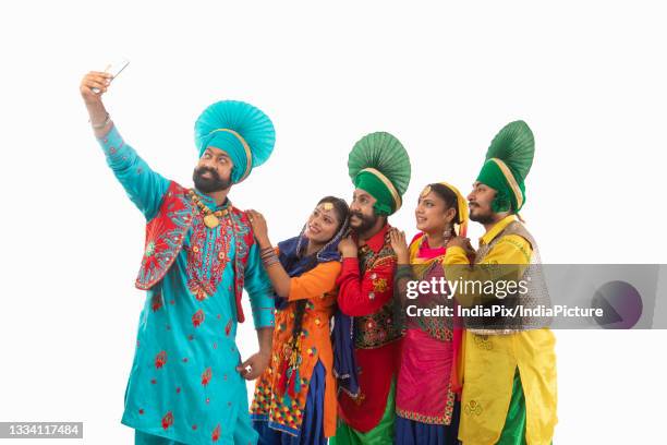 a troupe of punjabi folk dancers clicking a selfie together. - bhangra fotografías e imágenes de stock