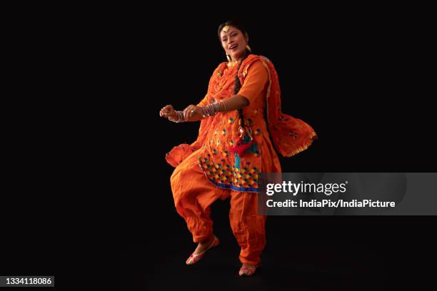 a woman in giddha costume depicting a dance step. - punjab stock pictures, royalty-free photos & images