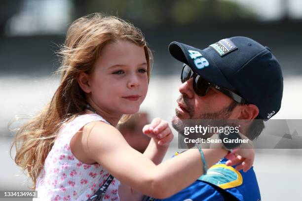 Jimmie Johnson of the United States, driver of the Carvana Chip Ganassi Racing Honda, holds his daughter, Lydia Norriss on the grid prior to the NTT...