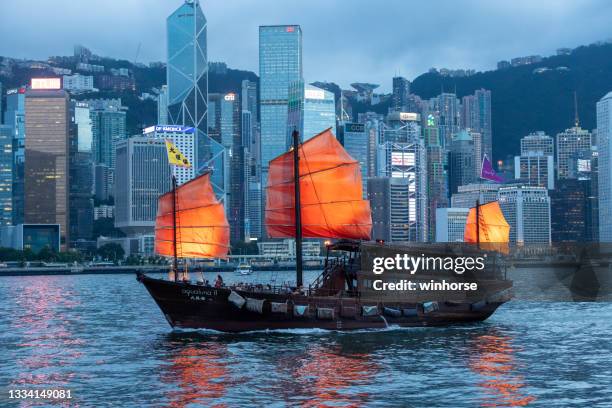 chinese old junk on victoria harbour at dusk in hong kong - hsbc stock pictures, royalty-free photos & images