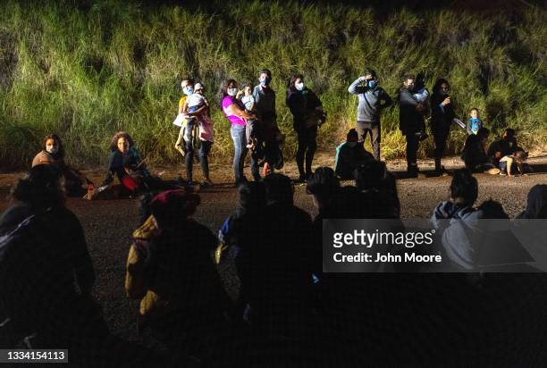 Immigrants wait to be processed by U.S. Border Patrol agents after they crossed the Rio Grande from Mexico on August 14, 2021 in Roma, Texas. Recent...