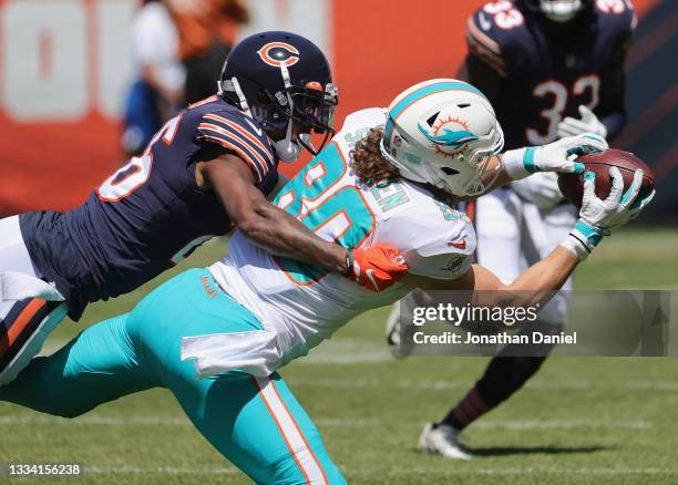 Adam Shaheen of the Miami Dolphins attempts to make a catch under pressure from Deon Bush of the Chicago Bears during a preseason game at Soldier...