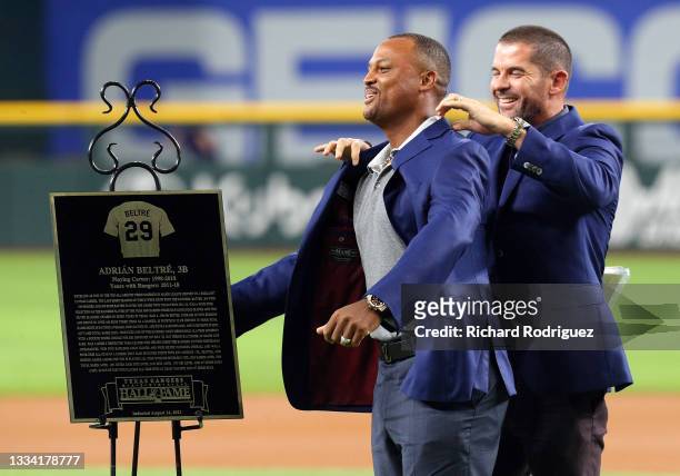 Former Texas Rangers third baseman Adrian Beltre gets a jacket from former teammate Michael Young as he is inducted into the Texas Rangers Hall of...