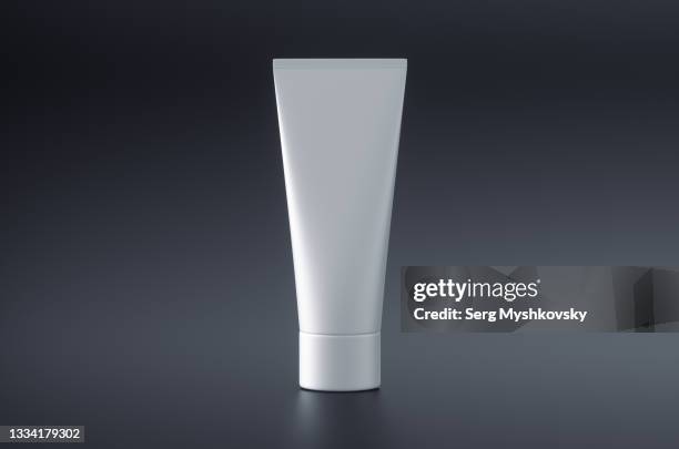 close-up of white template blank packaging tube of face cream on black background. - cream tube stock pictures, royalty-free photos & images