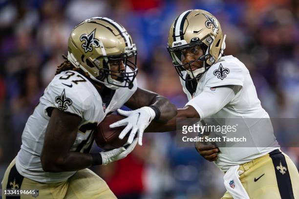 Jameis Winston of the New Orleans Saints hands the ball off to Tony Jones Jr. #37 during the first half of a preseason game against the Baltimore...
