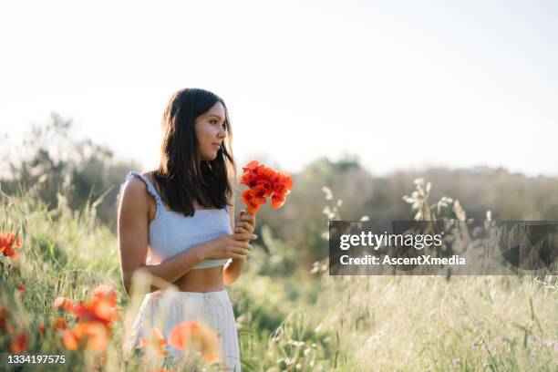 une jeune femme se détend dans la zone des fleurs sauvages, en été - pantalon large photos et images de collection