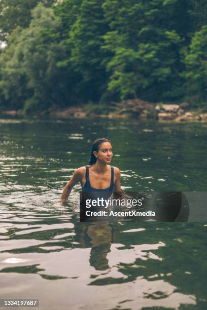 giovane donna esce dal lago d'acqua dolce - pianta selvatica foto e immagini stock
