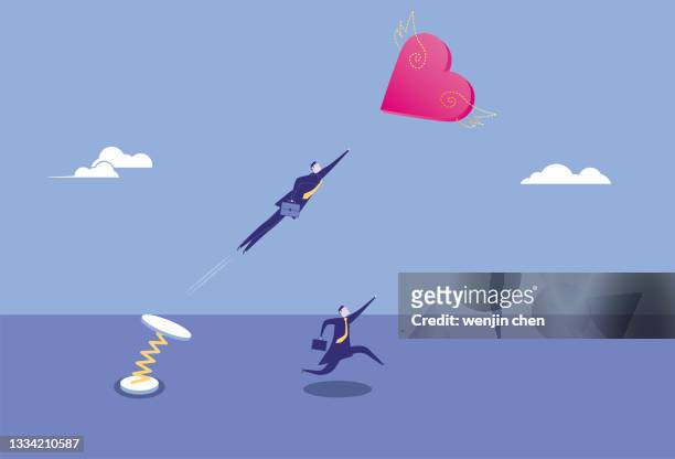 the spiral spring helps one of the business men catch the flying heart shape - abzeichen stock illustrations