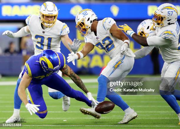 Jacob Harris of the Los Angeles Rams fumbles the ball against Nick Niemann, Alohi Gilman and Amen Ogbongbemiga of the Los Angeles Chargers during the...