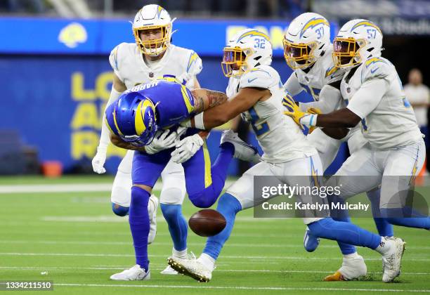 Jacob Harris of the Los Angeles Rams fumbles the ball against Nick Niemann, Alohi Gilman and Amen Ogbongbemiga of the Los Angeles Chargers during the...