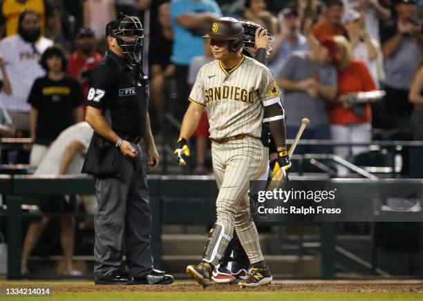 Ha-Seong Kim of the San Diego Padres reacts as he walks back to the dugout after being called out on strikes by home plate umpire Scott Barry during...