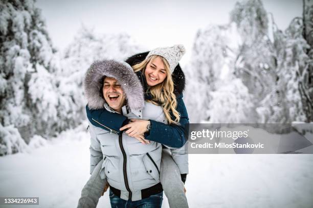 feliz pareja en un día nevado - winter coat fotografías e imágenes de stock