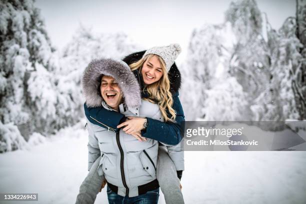 happy couple on a snowy day - happy couple cuddle stockfoto's en -beelden