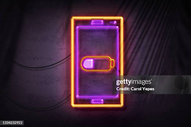 low batery cell phone in neon lights style - battery low stock-fotos und bilder