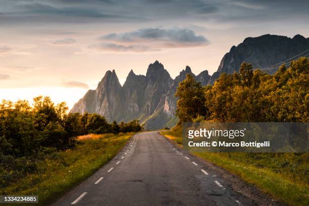 road leading to sharp mountain peaks, senja island, norway - finnmark county stock pictures, royalty-free photos & images