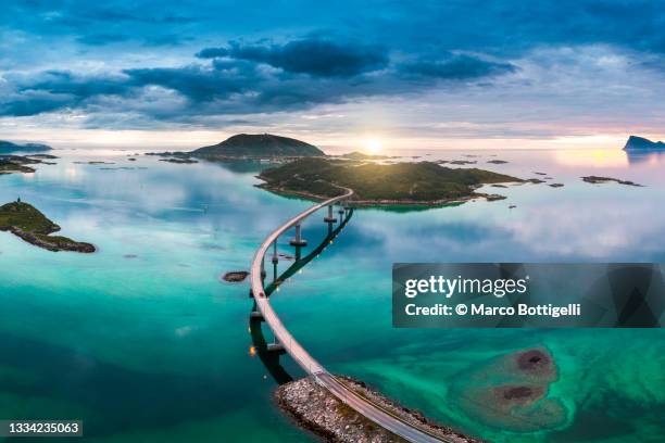 bridge to sommaroy and midnight sun, tromso, norway - beeindruckt stock-fotos und bilder