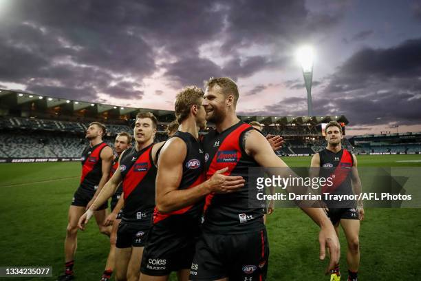 Darcy Parish and Jake Stringer of the Bombers embrace after the round 22 AFL match between Gold Coast Suns and Essendon Bombers at GMHBA Stadium on...