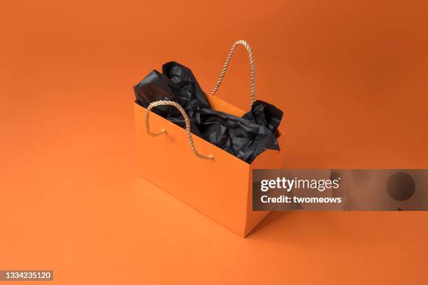 one orange colour shopping bag on orange background. - tragetasche oder tragebeutel stock-fotos und bilder