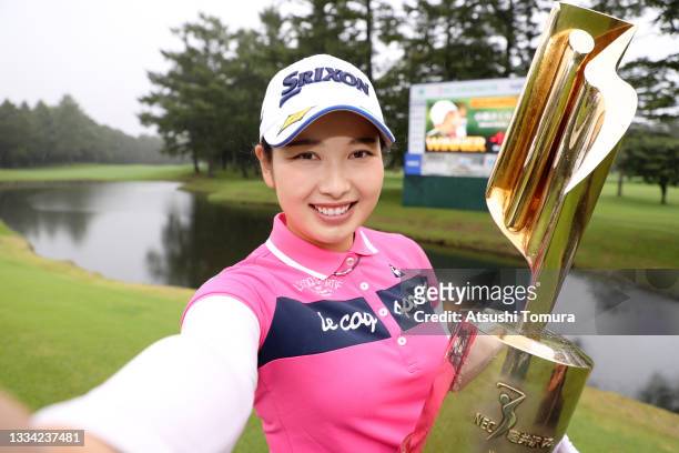 Sakura Koiwai of Japan imitates the selfie after winning the tournament following the final round of the NEC Karuizawa 72 Golf Tournament at...