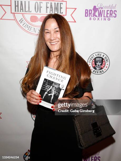 Author and former boxer Alicia Doyle holds up her book "Fighting Chance" during the 2020-2021 International Women's Boxing Hall of Fame induction...