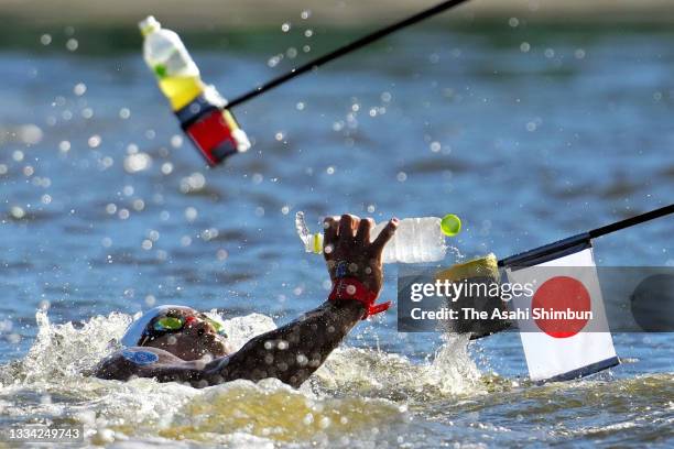 Taishin Minamide of Team Japan picks up a water bottle while competing in the Men's 10km Marathon Swimming on day thirteen of the Tokyo 2020 Olympic...