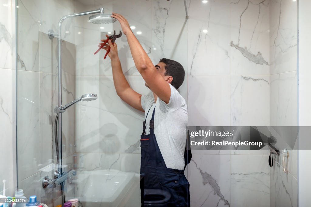 Klempner repariert einen Wasserhahn im Badezimmer