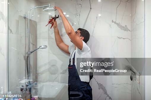 Plumber repairing a tap in the bathroom Plumber repairing a tap in the bathroom