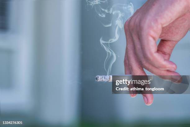 man hand holding cigarette. - sigaretta foto e immagini stock