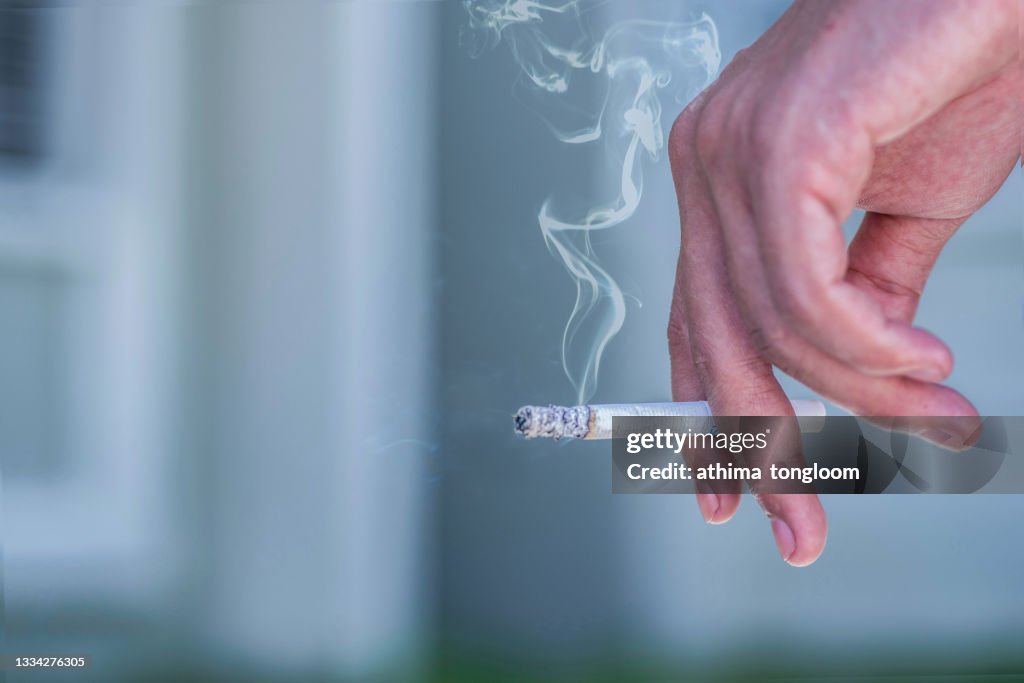 Man hand holding cigarette.