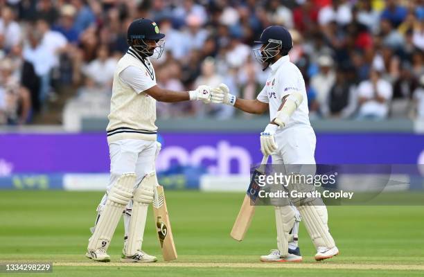 Ajinkya Rahane and Cheteshwar Pujara of India punch gloves during day four of the Second LV= Insurance Test Match between England and India at Lord's...