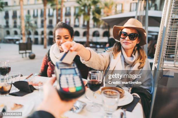 woman payng in restaurant - commercial activity 個照片及圖片檔