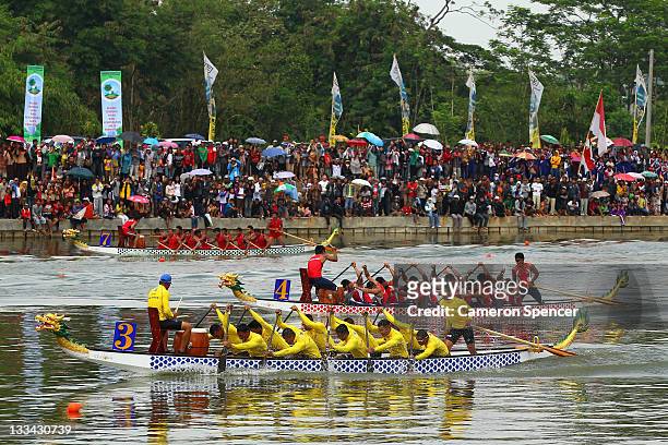 The Philippines Men's 12 crew lead competitors during traditional boat racing on day nine of the 2011 Southeast Asian Games at Danau Cipule on...
