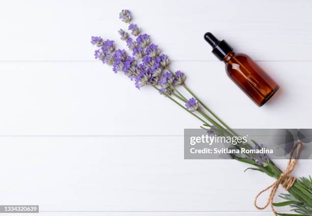 fresh lavender and cosmetic bottle on white wooden background with copyspace - twig photos et images de collection
