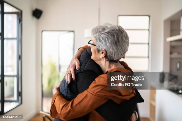 mother and son embracing at home - hugging son stock pictures, royalty-free photos & images