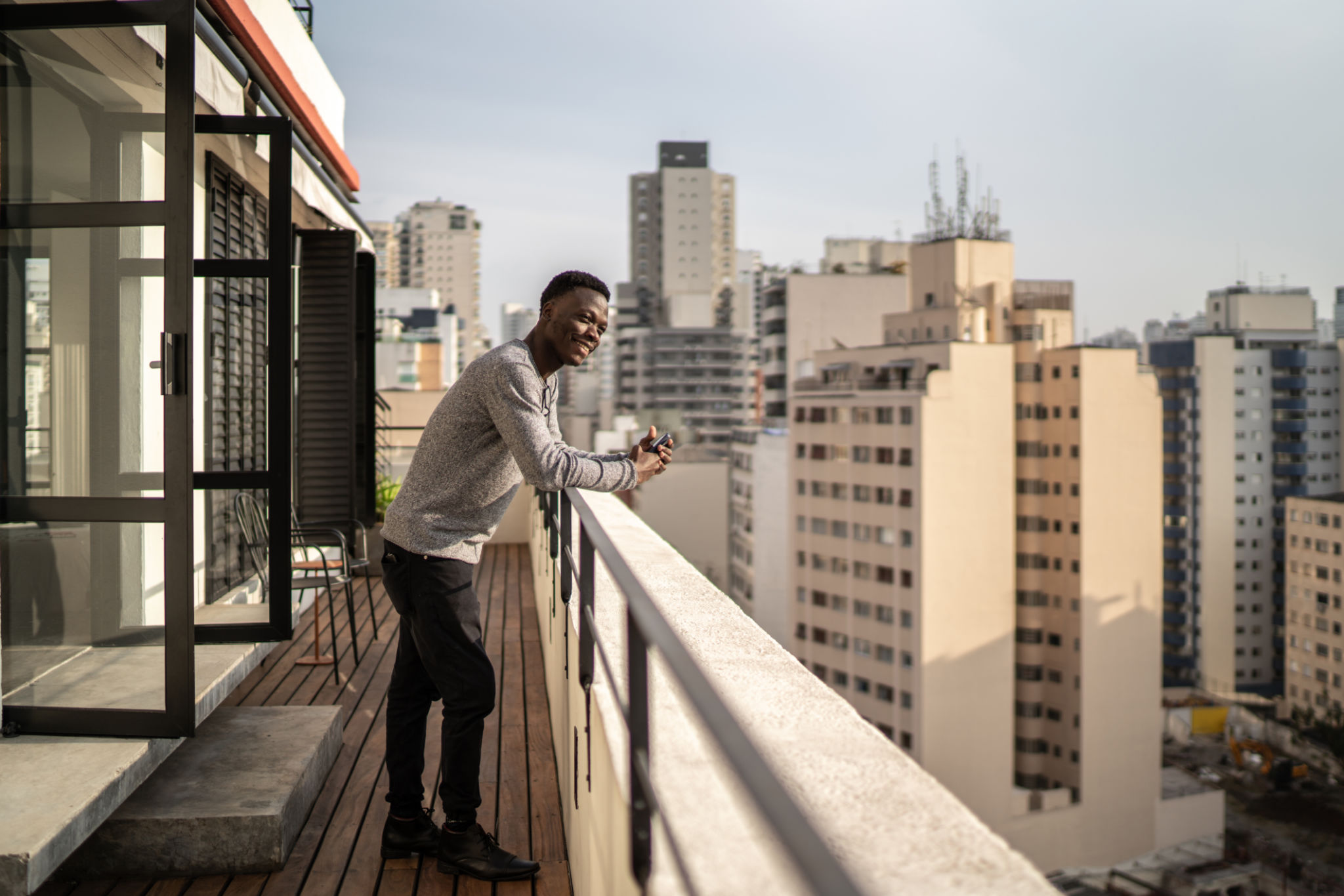 Young man contemplating from building terrace Young man contemplating from building terrace