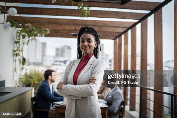 porträt einer geschäftsfrau im freien - teambesprechung im hintergrund - work gender equality stock-fotos und bilder