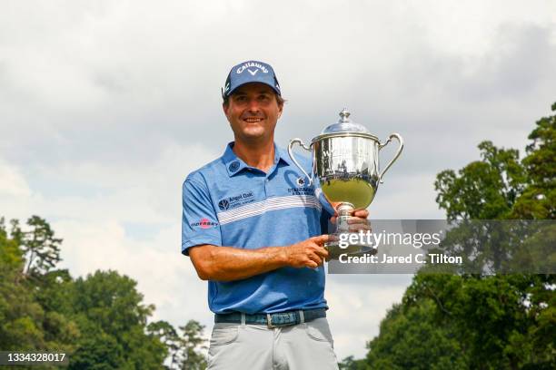 Kevin Kisner of the United States celebrates with the trophy after winning a 6-way sudden-death playoff during the final round of the Wyndham...