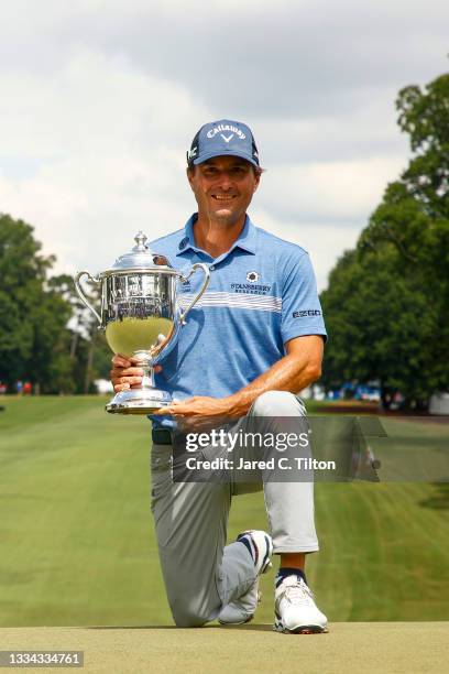 Kevin Kisner of the United States celebrates with the trophy after winning a 6-way sudden-death playoff during the final round of the Wyndham...