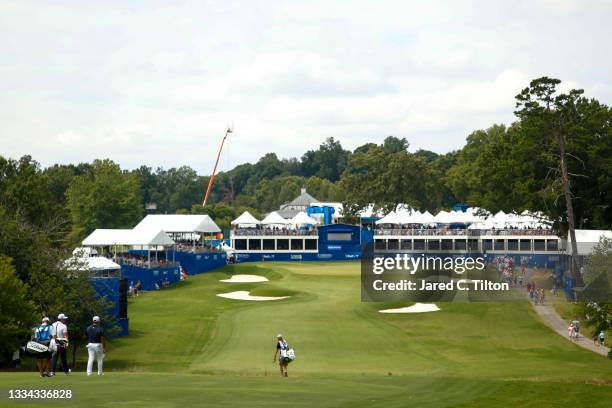 The group of Si Woo Kim of South Korea, Sung Kang of Korea and Sungjae Im of Korea walk the 18th hole during the final round of the Wyndham...