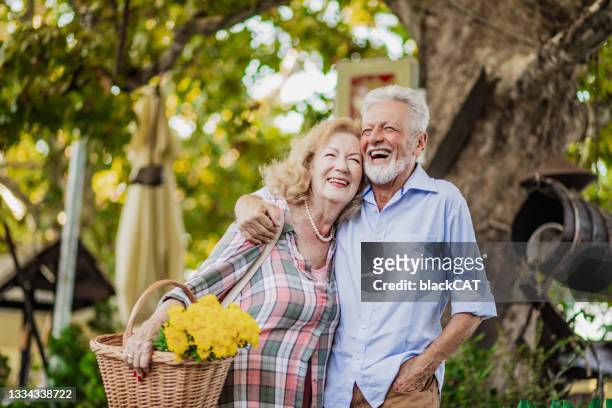 senior couple enjoying walking outside on a nice sunny day - 老年情侶 個照片及圖片檔