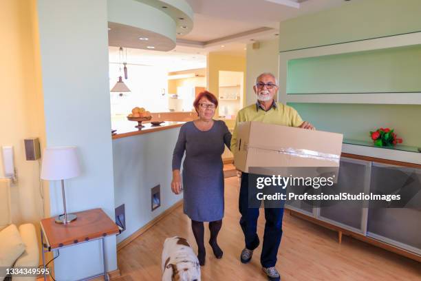 cheerful senior couple is delighted while entering a new home. - city on the move stock pictures, royalty-free photos & images