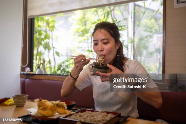 日本料理店で天ぷらそばを食べる日本人女性 - 天ぷら ストックフォトと画像
