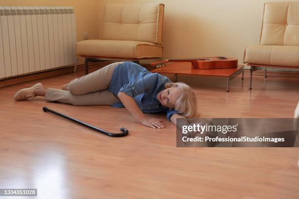 senior woman with walking stick lying in the living room after a terrible accident. - fainting 個照片及圖片檔