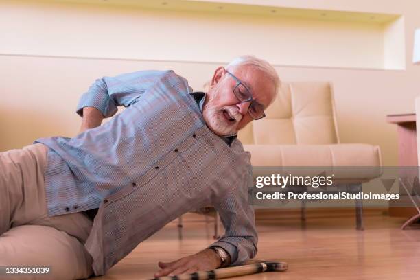 a senior man with walking cane had an accident and fell on the floor. - tropeçar imagens e fotografias de stock