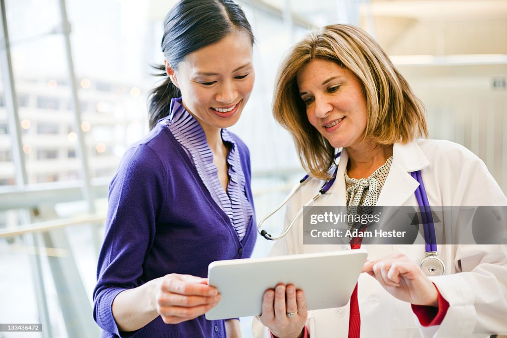 A doctor and patient working on a tablet together.