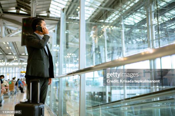 businessman using mobile phone in the airport. - thailand covid stock pictures, royalty-free photos & images