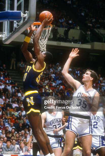 David Robinson of the Navy Midshipman shoots over Danny Ferry of the Duke Blue Devils during an NCAA basketball game March 23, 1986 at the Brendan...