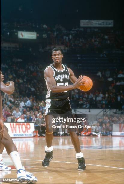 David Robinson of the San Antonio Spurs looks to pass the ball against the Washington Bullets during an NBA basketball game circa 1992 at the Capital...